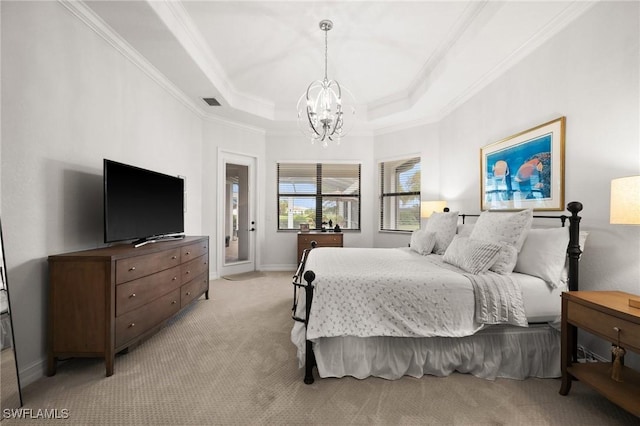 carpeted bedroom with a chandelier, a tray ceiling, and ornamental molding