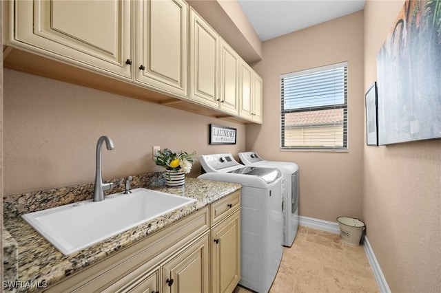 laundry room with cabinets, independent washer and dryer, and sink