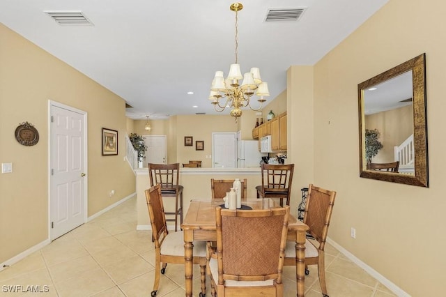 tiled dining area with a chandelier