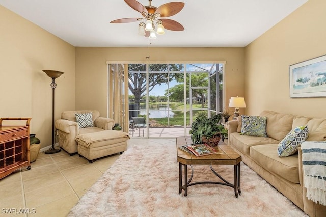 tiled living room with a water view and ceiling fan