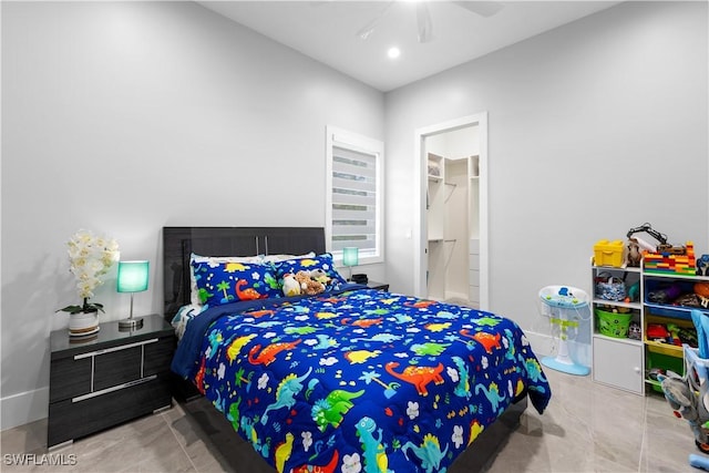 bedroom with a walk in closet, ceiling fan, a closet, and light tile patterned floors