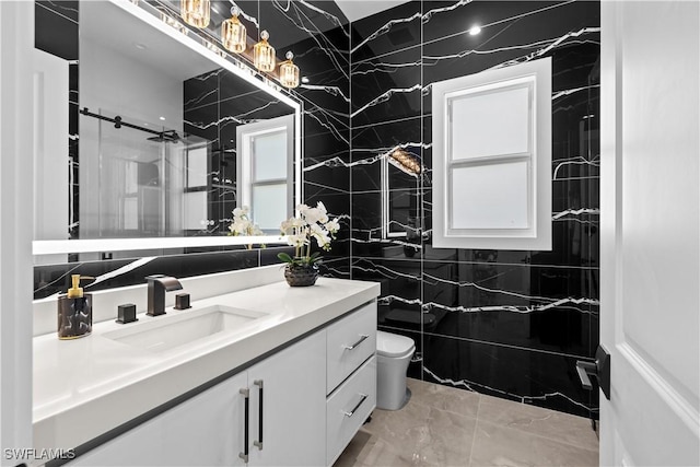 bathroom featuring a shower, vanity, tile walls, and toilet