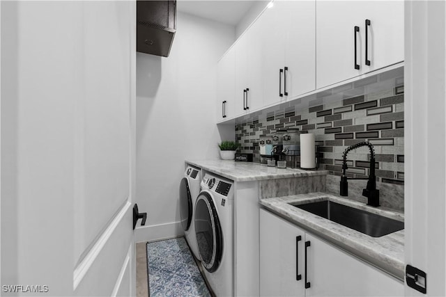 washroom featuring cabinets, washer and clothes dryer, and sink