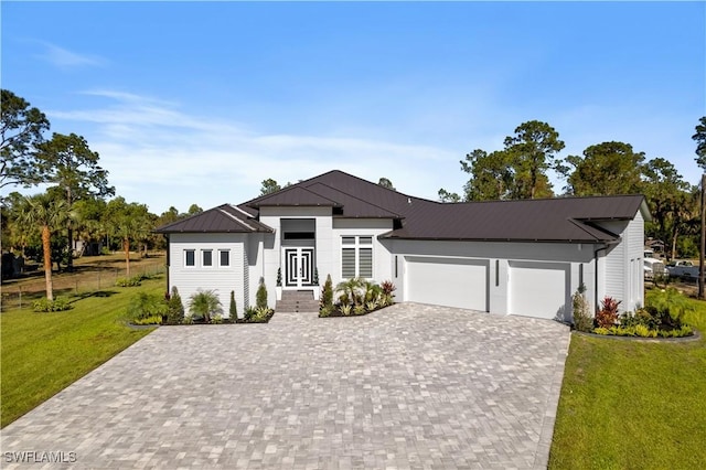 view of front of home with a garage and a front lawn