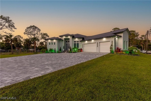 view of front of house featuring a garage and a lawn