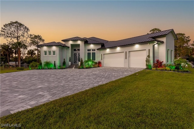 view of front of house with a yard and a garage