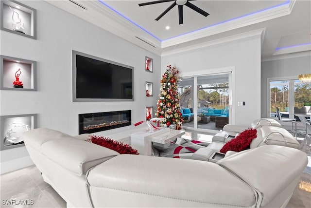 living room featuring ceiling fan, a raised ceiling, ornamental molding, and light tile patterned floors