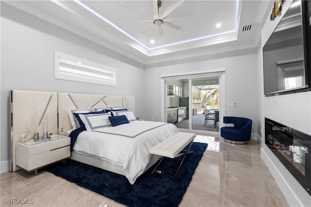 bedroom with a tray ceiling, access to exterior, ceiling fan, and crown molding