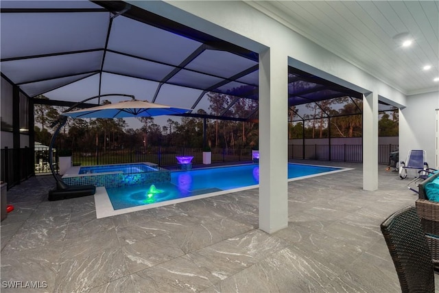 pool at dusk featuring a lanai, an in ground hot tub, pool water feature, and a patio