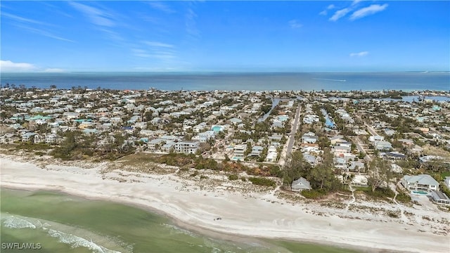 drone / aerial view featuring a beach view and a water view