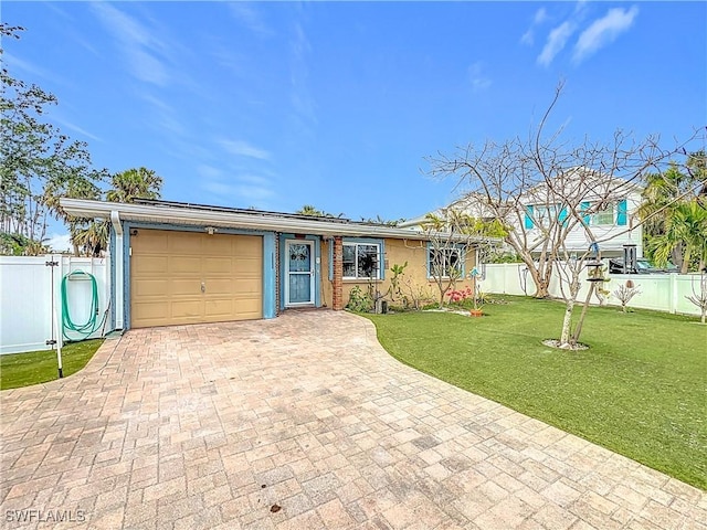 ranch-style home with solar panels, a garage, and a front yard