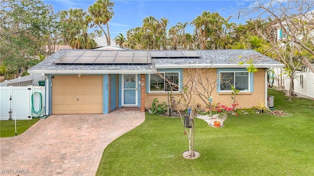 view of front facade with solar panels, a garage, and a front yard