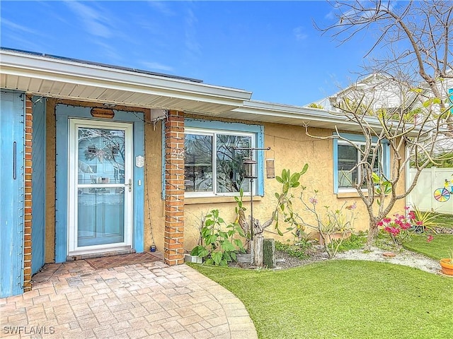 doorway to property with a yard