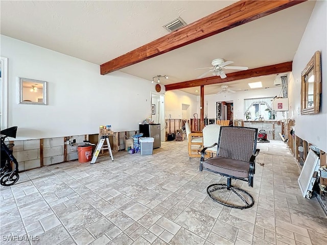 living room featuring ceiling fan and beam ceiling