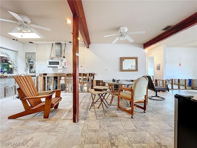 dining room with beamed ceiling and ceiling fan