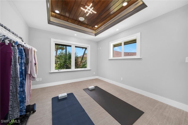 workout area with carpet flooring, a raised ceiling, and wood ceiling