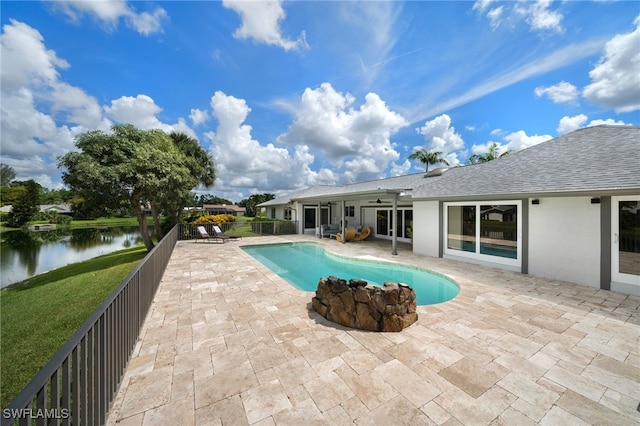 view of swimming pool featuring ceiling fan, a water view, and a patio