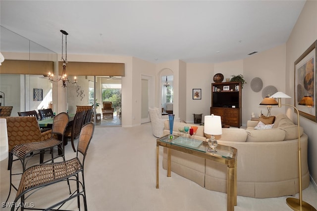 living room featuring a chandelier and light carpet