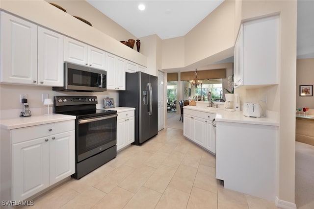 kitchen featuring white cabinetry, stainless steel appliances, sink, and a notable chandelier