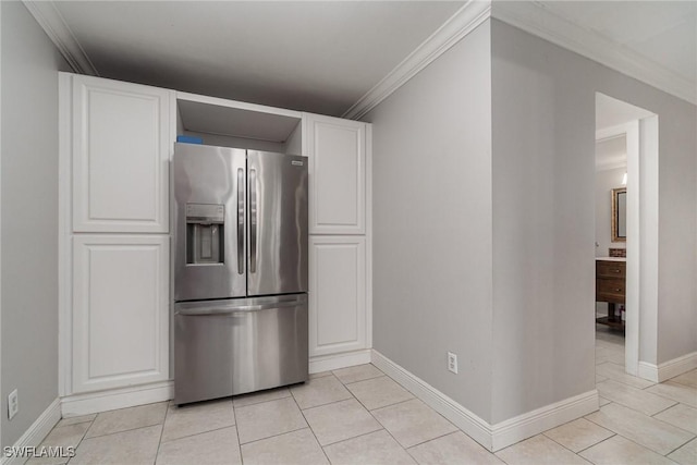 kitchen with white cabinets, stainless steel fridge, ornamental molding, and light tile patterned floors