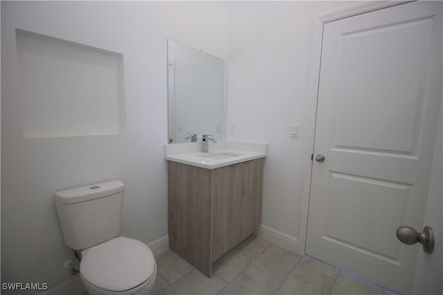 bathroom featuring tile patterned floors, vanity, and toilet