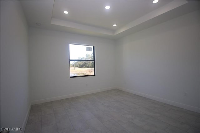 unfurnished room with a tray ceiling