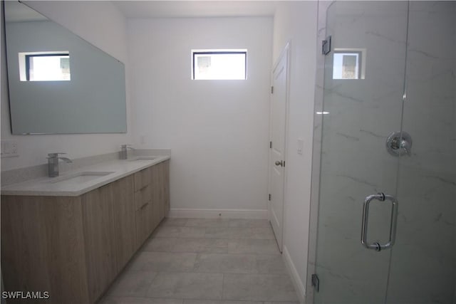 bathroom featuring vanity, a shower with door, and a healthy amount of sunlight