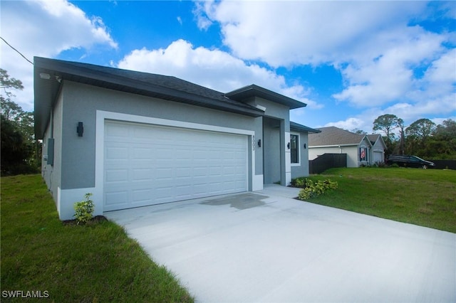 view of front of home with a front yard, concrete driveway, a garage, and stucco siding