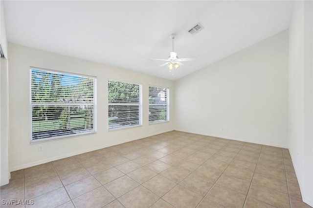 spare room with ceiling fan, a wealth of natural light, and light tile patterned flooring