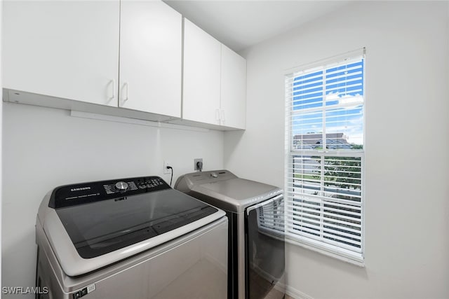 laundry area featuring cabinets and washing machine and clothes dryer