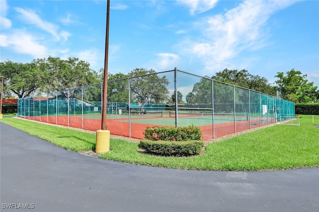 view of tennis court featuring a lawn