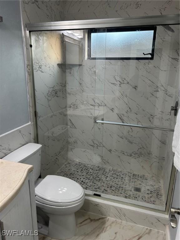 bathroom with vanity, toilet, and a shower with door