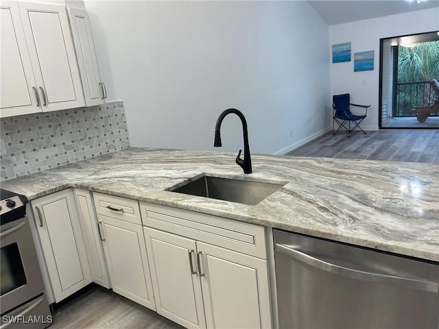 17658 Osprey Inlet Ct W, Fort Myers, FL 33908 - kitchen featuring stainless steel appliances, wood finished floors, decorative backsplash, and white cabinets