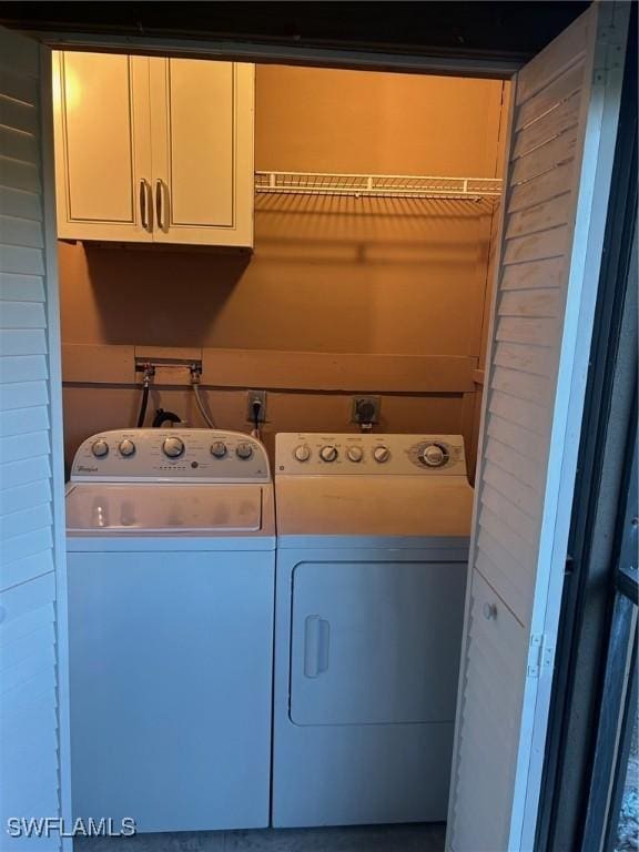 laundry room featuring washing machine and dryer and cabinets