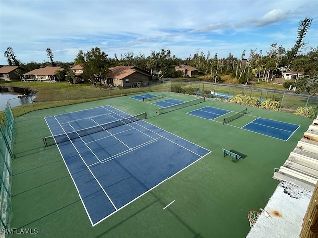 view of tennis court with a water view