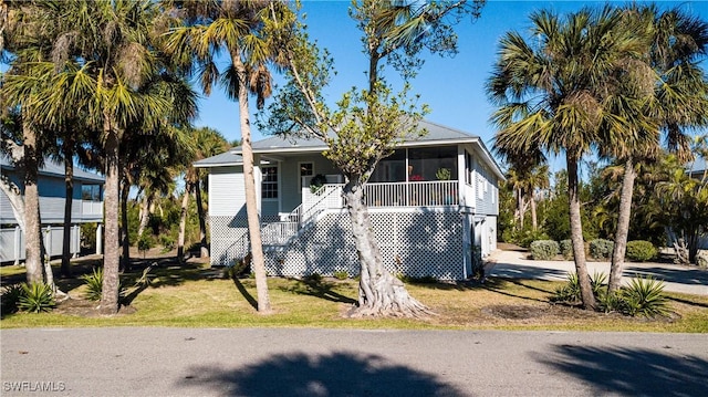 view of front of home featuring a sunroom and a front yard