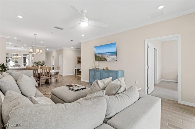 living room featuring light hardwood / wood-style floors, ceiling fan with notable chandelier, and ornamental molding