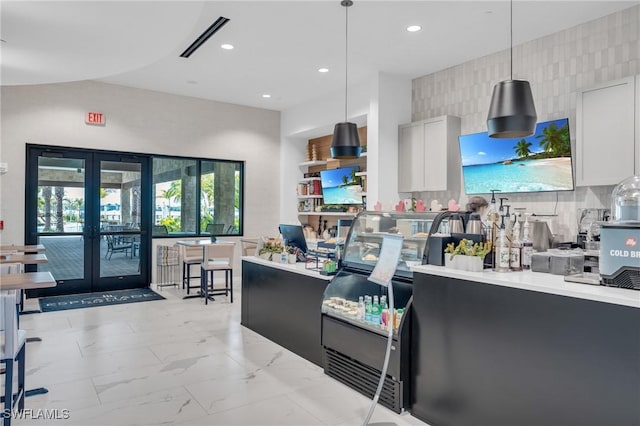 kitchen featuring white cabinetry, french doors, and decorative light fixtures