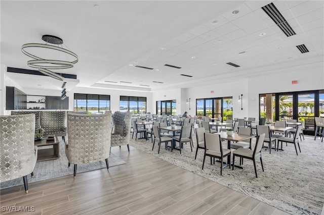 dining room with light hardwood / wood-style floors and french doors