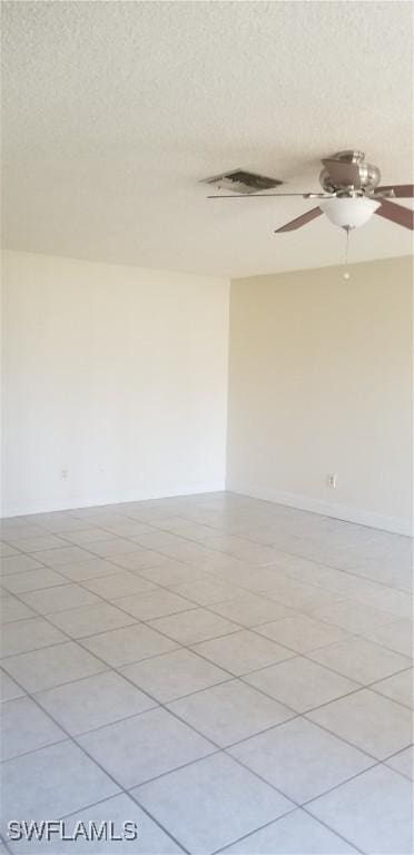 tiled spare room featuring ceiling fan and a textured ceiling