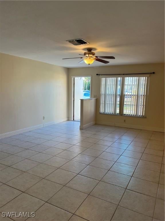 tiled spare room with ceiling fan