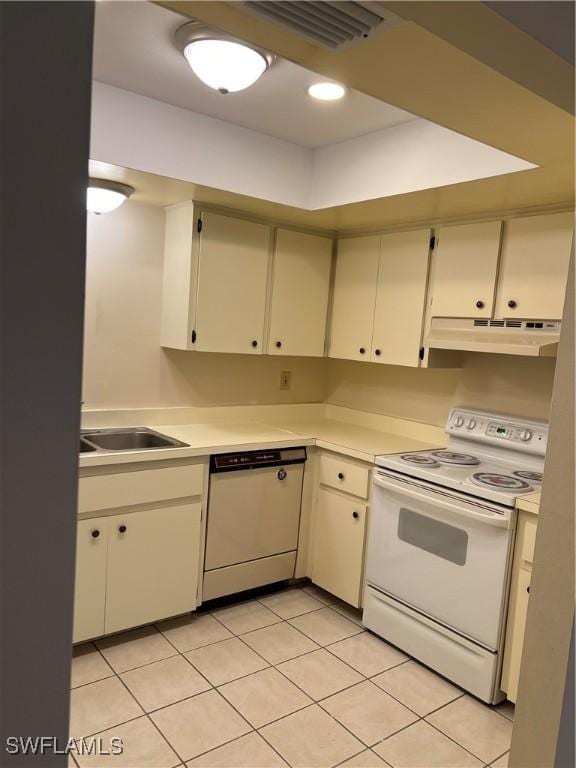 kitchen with light tile patterned floors, white appliances, and sink