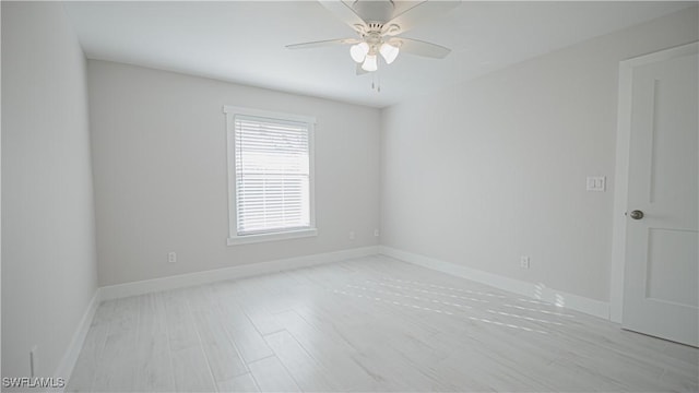 spare room featuring light wood-type flooring, ceiling fan, and baseboards