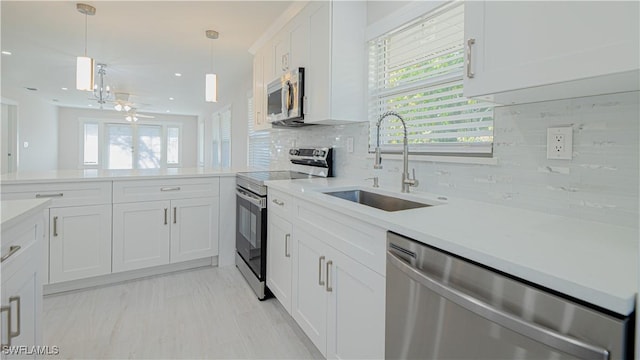 kitchen featuring stainless steel appliances, a sink, light countertops, and white cabinets