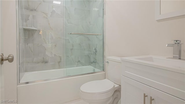 bathroom with vanity, toilet, and bath / shower combo with glass door