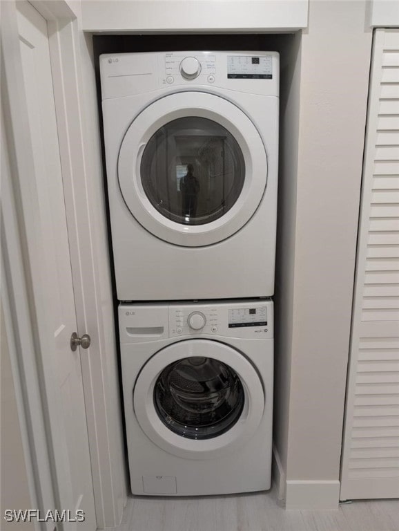 2836 Arbutus St Unit A1, Naples, FL 34112 - laundry area featuring stacked washing machine and dryer and baseboards