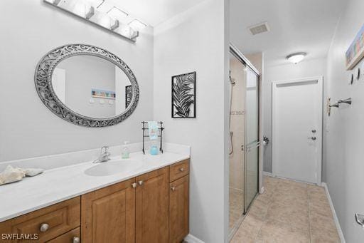 bathroom with tile patterned flooring, vanity, and walk in shower