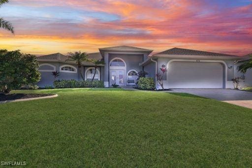 view of front of property with a yard and a garage