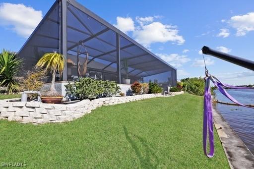 view of yard with glass enclosure and a water view