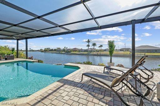 view of swimming pool featuring a patio, a water view, and a lanai